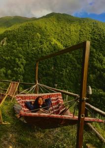 Eine Frau, die in einer Hängematte auf einem Berg liegt. in der Unterkunft Qaldea Resort in Uschguli