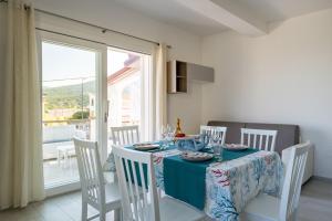 ein Esszimmer mit einem Tisch, Stühlen und einem Fenster in der Unterkunft Stella del mare in Cala Gonone