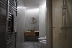 een badkamer met een toilet, een wastafel en een spiegel bij Gallurasuite in Luras