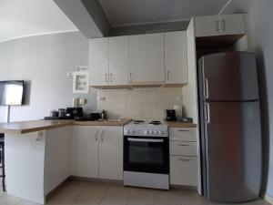 a kitchen with white cabinets and a stainless steel refrigerator at D3 Executive Studio in Athens