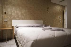 een slaapkamer met een wit bed en handdoeken bij Gallurasuite in Luras
