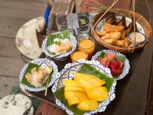 a wooden table with plates of food on it at Ayutthaya retreat in Phra Nakhon Si Ayutthaya