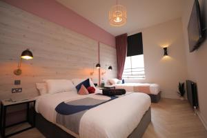 Una habitación de hotel con dos camas y un televisor. en Revolver, en Glasgow