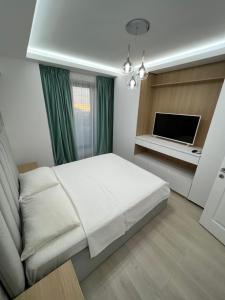 ママイアにあるPatrick Apartmentsのベッドルーム(白いベッド1台、テレビ付)