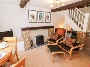 a living room with a fireplace and a table and chairs at Hock-tide Cottage in Kenilworth