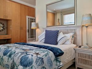a bedroom with a bed and a mirror at 'The View' on Bikini Beach, Seafront, 2 bedroom, Sleeps 4 in Gordonʼs Bay