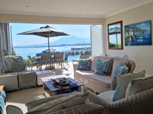 a living room with couches and an umbrella at 'The View' on Bikini Beach, Seafront, 2 bedroom, Sleeps 4 in Gordonʼs Bay