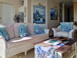 a living room with a couch and a table at 'The View' on Bikini Beach, Seafront, 2 bedroom, Sleeps 4 in Gordonʼs Bay