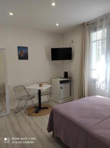 a bedroom with a bed and a table and a tv at Chambre accueillante à 2 mn du centre ville in Perpignan