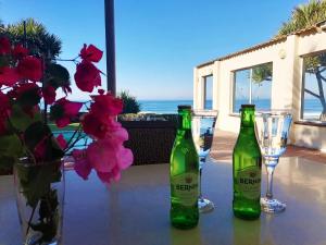 マーゲートにあるSouthern Comfort - On the Poolの緑のボトル2本、花のテーブルの上のグラス