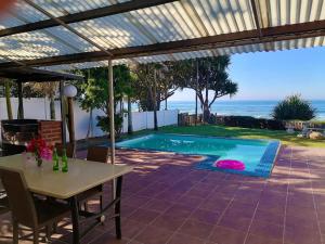 un patio con una mesa y una piscina en Southern Comfort - On the Pool, en Margate