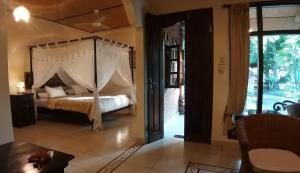 a bedroom with a bed with a canopy at Rambutan Hotel in Lovina