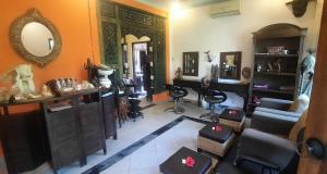a living room filled with furniture and a mirror at Rambutan Hotel in Lovina