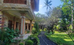 an outside view of a house with a garden at Rambutan Hotel in Lovina