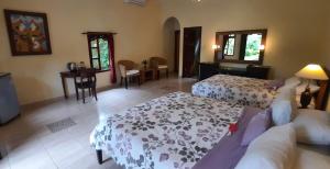 a bedroom with two beds and a living room at Rambutan Hotel in Lovina