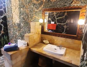 a bathroom with a sink and a mirror at Rambutan Hotel in Lovina