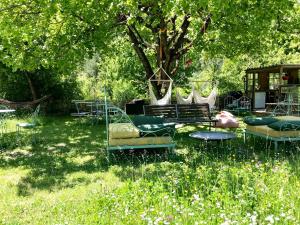 a group of beds in the grass under a tree at Mas de la Pauze in Reilhanette
