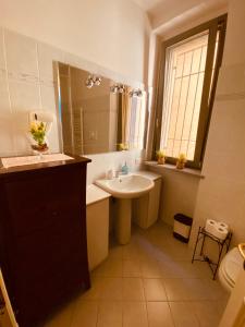 W łazience znajduje się umywalka i lustro. w obiekcie Amici Miei Rooms w mieście Cremona
