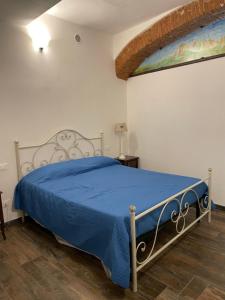 1 dormitorio con 1 cama con colcha azul en B&B bottega 11, en Burchio