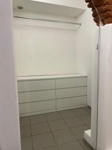 a room with a closet with white walls and a tile floor at B&B bottega 11 in Burchio