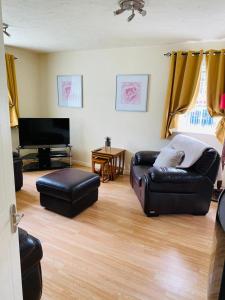 uma sala de estar com um sofá de couro e um piano em Lindeburgh Retreat em Newport