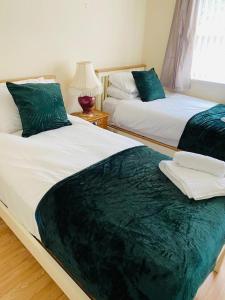 Duas camas sentadas uma ao lado da outra num quarto em Lindeburgh Retreat em Newport