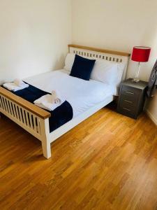 um quarto com uma cama grande e piso em madeira em Lindeburgh Retreat em Newport