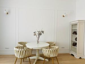 a white dining room with a white table and chairs at Suite № 7 in Braşov