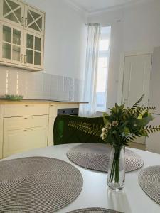 Suite № 7 في براشوف: مطبخ مع طاولة عليها إناء من الزهور