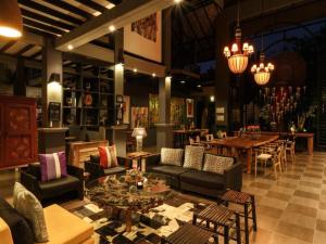 un vestíbulo con sofás y mesas y un comedor en Baan Suan Residence เฮือนพักบ้านสวน, en Chiang Mai