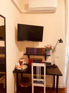 Pokój z biurkiem, telewizorem i krzesłem w obiekcie Amici Miei Rooms w mieście Cremona