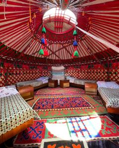 a interior of a yurt with beds and a rug at Guesthouse Gulmira in Bokonbayevo