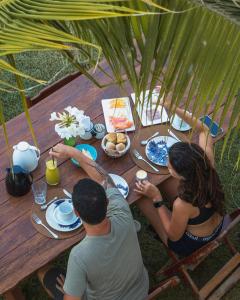 a man and a woman sitting at a picnic table at Villa Siriguela in Icaraí