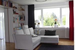 sala de estar con sofá blanco y ventana en Das Blaue Haus - Ferienwohnung Schönherr en Kassel