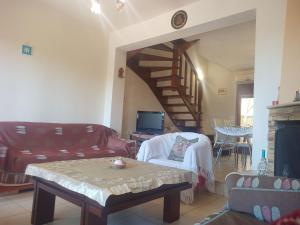 sala de estar con sofá, mesa y escalera en ΜΕΖΟΝΕΤΑ en Néa Ródha