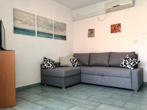 a living room with a couch and paintings on the wall at Lovely studio apartment Mare e Sole in Labin