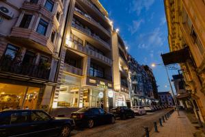 a city street with cars parked in front of buildings at Hotel Monarch in Batumi