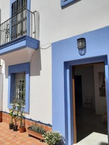 un bâtiment bleu et blanc avec une porte et des plantes dans l'établissement Villa Puerto Santa María, à El Puerto de Santa María