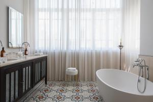a bathroom with a tub and a toilet and a sink at The Norman Tel Aviv in Tel Aviv