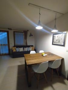 a dining room with a wooden table and white chairs at Appartamento Dellantonio in Predazzo