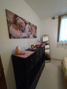 ein Zimmer mit einer Kommode mit einem Gemälde an der Wand in der Unterkunft Appartamento Dellantonio in Predazzo