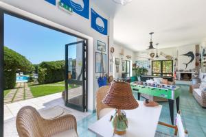 a living room with a glass door and a game table at Residence Punta Cassano - In piscina sulla spiaggia di sabbia in San Foca