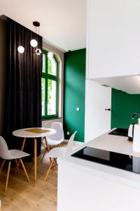a kitchen with a table and chairs and a green wall at Willa Kryniczanka in Krynica Morska