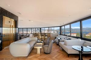 a living room with couches and tables and windows at Hotel San Carlu Citadelle Ajaccio in Ajaccio