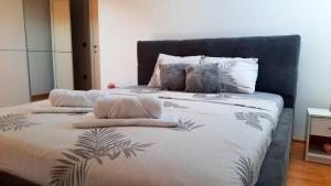 a bed with two pillows on top of it at Loft apartman in Jagodina