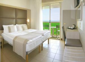 a bedroom with a large bed and a balcony at Hotel Bristol in Lido di Jesolo