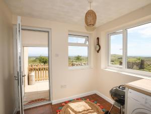 a kitchen with windows and a view of a balcony at Cwm Ceiliog Annex in Caernarfon