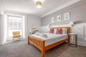 a bedroom with a large bed and a chair at The Doctor's House Central with Street Parking in St. Andrews