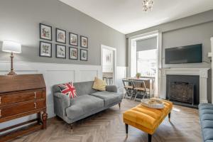 a living room with a couch and a tv at The Doctor's House Central with Street Parking in St. Andrews