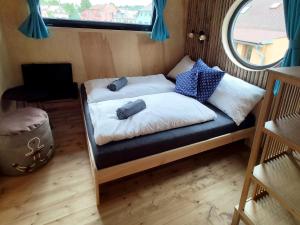 a small bed in a tiny house with a window at Chata NEMO in Hlinsko